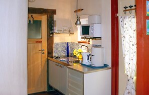 A compact kitchen with a microwave, sink, and a coffee maker. - Cozy apartment in Röbel with lake view (Röbel)