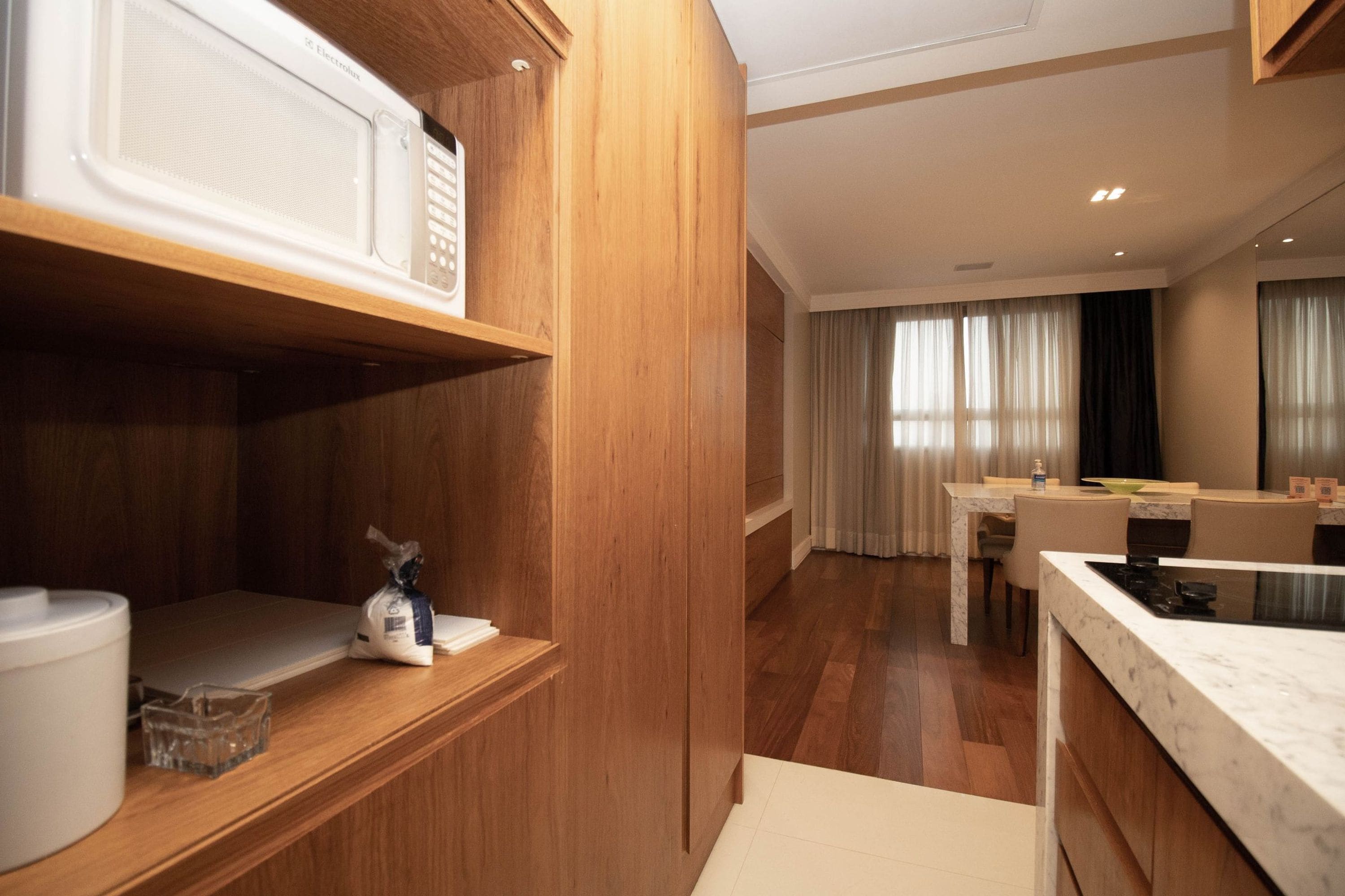 Een moderne keuken met houten kastjes en een marmeren aanrecht.