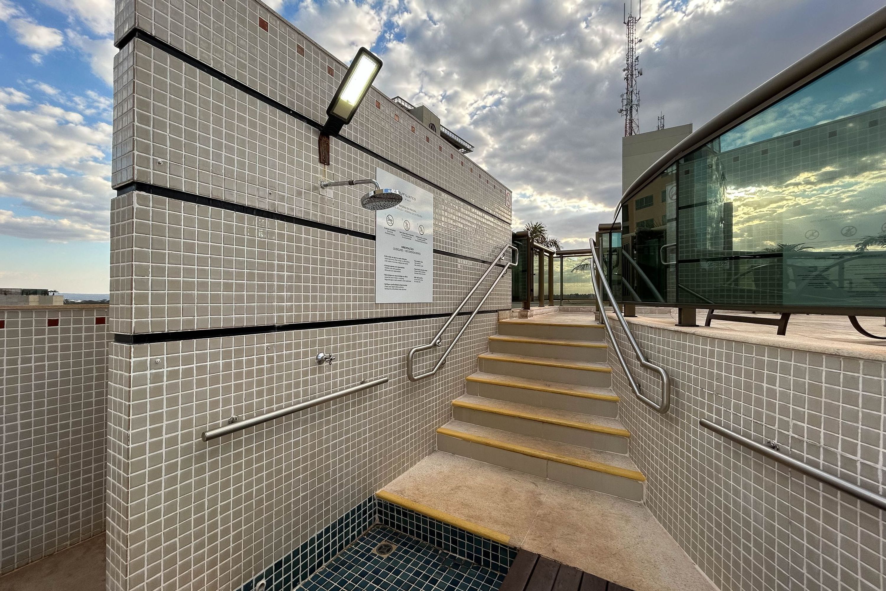 Una escalera con baldosas que lleva a un balcón con vistas al cielo y las nubes.