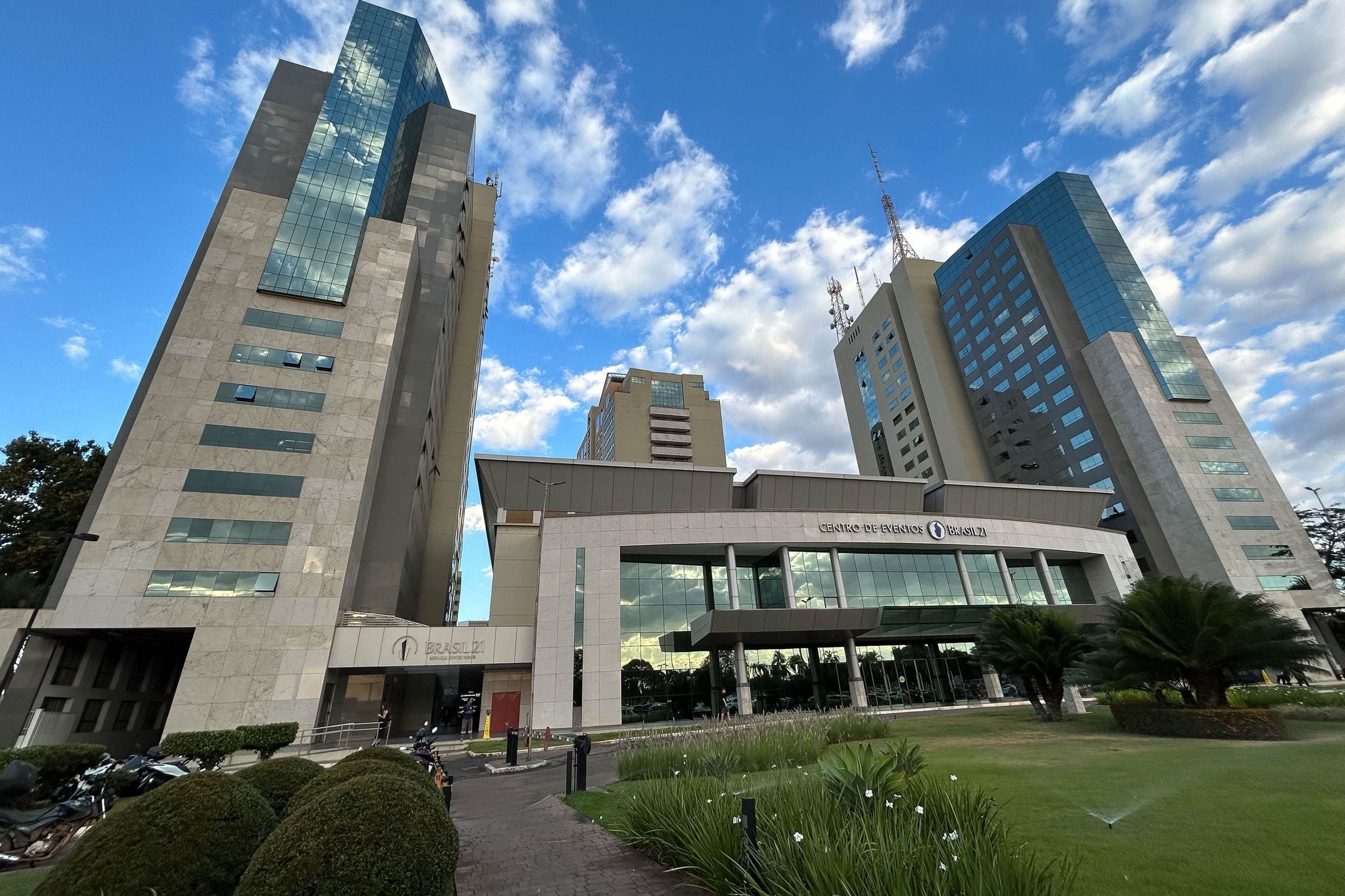 Een modern gebouw met een glazen gevel en een bord met de tekst 'CENTRO DE EVENTOS BRASIL 21'.