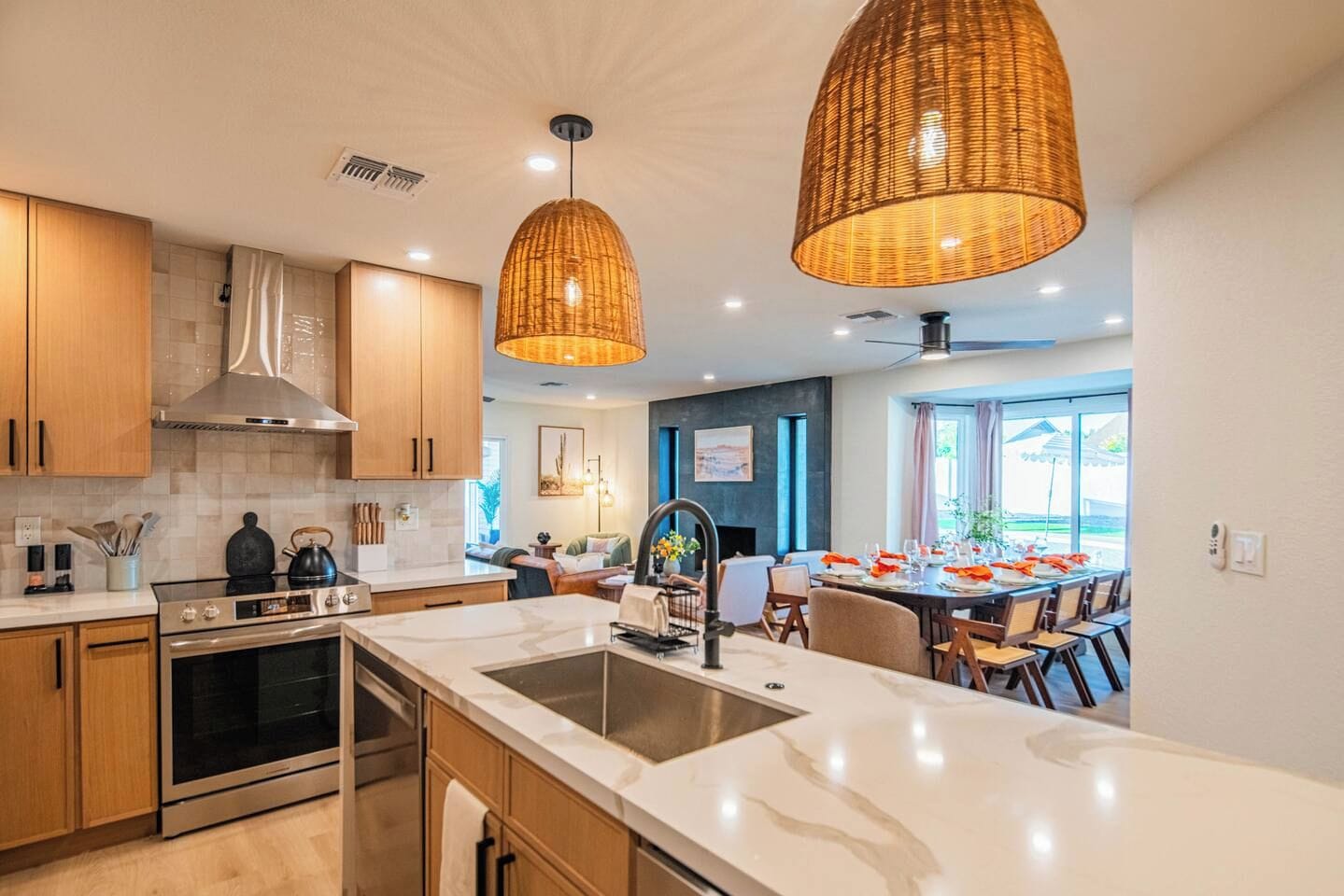 A modern kitchen with stainless steel appliances, wooden cabinets, and a large island with a sink.