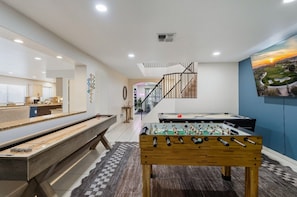 A modern interior with a foosball table, a pool table, and a kitchen area. - Resort-Style Retreat: Pool • Spa • Game Room (Scottsdale)