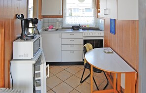 A compact kitchen with a stove, oven, and a small dining table. - Nice home in Sydals with WiFi (Sydals)