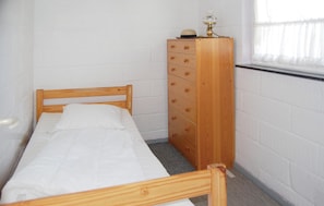 A small, single-bed room with a wooden headboard and a dresser with drawers. - Nice home in Sydals with WiFi (Sydals)
