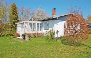 A white house with a covered porch, a chimney, and a garden with grass and trees. - Nice home in Sydals with WiFi (Sydals)