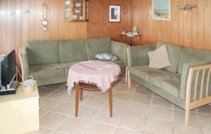 A living room with two green sofas, a wooden table with a pink tablecloth, and a tiled floor. - Nice home in Sydals with WiFi (Sydals)