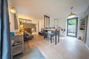Un intérieur moderne comprenant un espace cuisine, un coin repas et un espace détente avec un canapé et une table basse.