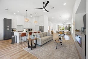 A spacious kitchen with modern appliances, a dining area with a chandelier, and a living room with a sofa and coffee table. - Golden Hour 1 story 4 BR 3-car garage GATED (Las Vegas)