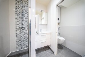 A modern bathroom with a shower, toilet, and vanity. - Le pied-à-terre idéal au centre (Quimper)
