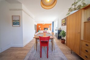 Ein Essbereich mit einem Holztisch, roten Stühlen und einer Hängelampe.