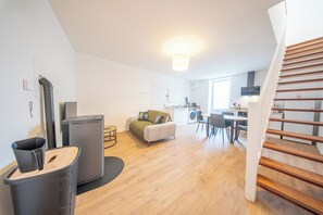 Eine moderne Wohnung mit Küche, Essbereich und einer Treppe.