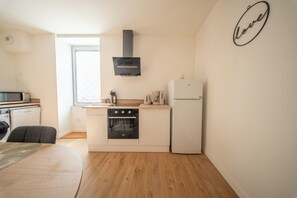 Eine kompakte Küche mit Herd, Backofen, Mikrowelle und Kühlschrank.