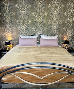 A bed with a herringbone-patterned headboard, two bedside lamps, and a patterned wallpaper. - Kaiserplatz Suite in a Prime Location (Bad Reichenhall)