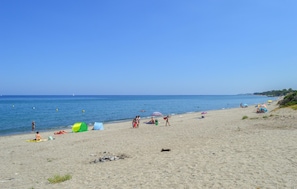 A beach with people sunbathing and swimming, tents, and a clear sky. - Amazing home in Folelli with private swimming pool, can be inside or outside (Folelli)