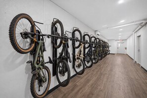 Ein langer Flur mit einem an der Wand befestigten Fahrradständer, der mehrere Fahrräder trägt.