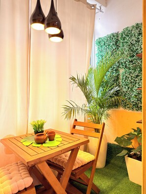 A cozy dining area with a wooden table, chairs, and a potted plant. - Cozy & Secure 1BR Apartment City Center (Luanda)