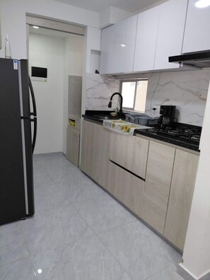 Una cocina moderna con refrigerador, estufa y gabinetes.