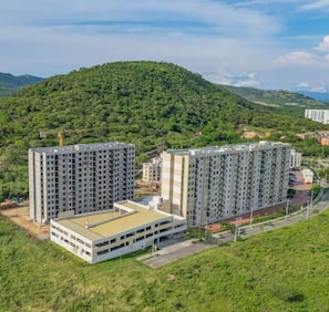 A residential complex with multiple high-rise buildings, surrounded by lush greenery and hills. - Lindo Apartamento con Piscina Girardot · Hasta 10 personas (Girardot)