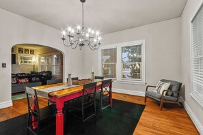 Ein Essbereich mit einem Holztisch, Stühlen und einer Chandelier.