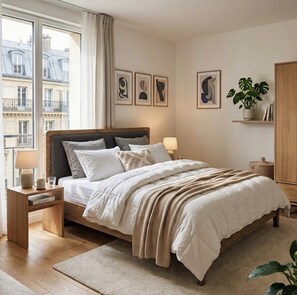 A bedroom with a bed, bedside tables, a nightstand, a lamp, a potted plant, and framed artwork on the wall. - Studio Apartment Between Bastille and Voltaire - Quiet Courtyard - Paris 11th Arrondissement (Paris)