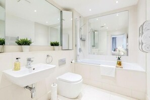 A modern bathroom with a sink, toilet, and bathtub. - Apartment Sleeps 4 Near Windsor Castle (Windsor)