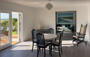 A dining area with a round table and chairs, a sofa, and a painting on the wall. - Amazing home in Nexø with WiFi (Nexø)