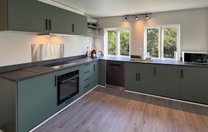A modern kitchen with a built-in oven, a dishwasher, and a large window providing natural light. - Amazing home in Nexø with WiFi (Nexø)