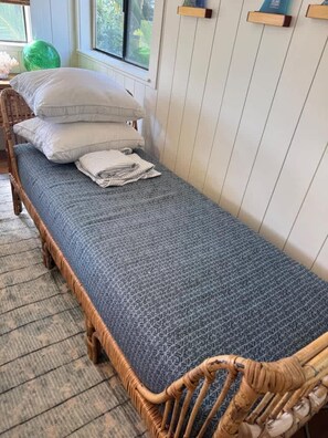 A single bed with a patterned bedspread, a wooden headboard, and pillows on a wooden floor. - Poipu Ocean View Beach House  - Sleeps 6 (Koloa)