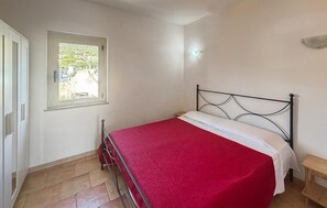 Ein Schlafzimmer mit einem Bett, einem Fenster und einer Tür.