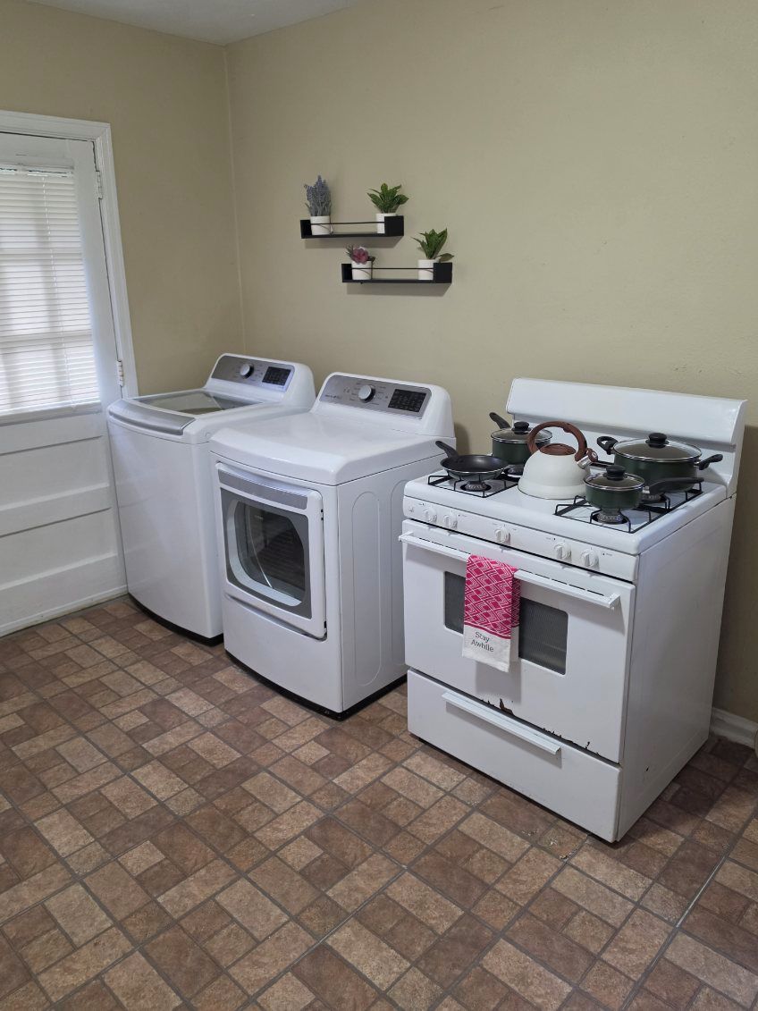 A laundry room with a washer, dryer, and stove.