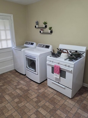 A laundry room with a washer, dryer, and stove. - Pershing Park Retreat (Montgomery)
