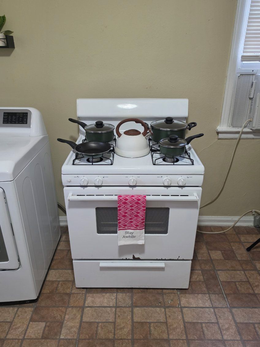 A kitchen with a stove, oven, and a washing machine.