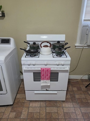 A kitchen with a stove, oven, and a washing machine. - Pershing Park Retreat (Montgomery)