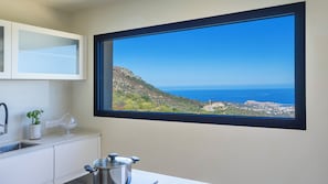 A bathroom with a large window, a sink, and a cabinet. - Villa Orizonte – Piscine à débordement et vue panoramique (Santa-Reparata-di-Balagna)
