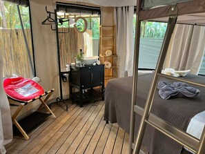 A compact room with a bunk bed, a small desk with a chair, and a window with a view of greenery. - Quaint 2-bedroom house in tranquil Savegre de Aguirre (Savegre de Aguirre)
