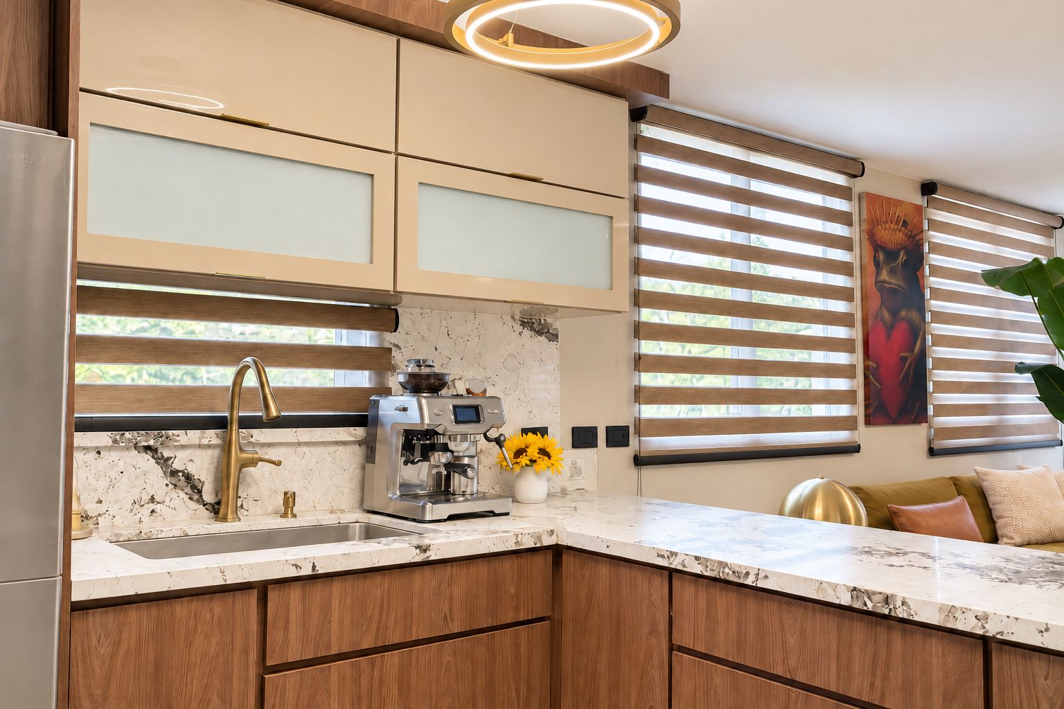 A modern kitchen with a built-in espresso machine, wooden cabinets, and a marble countertop.