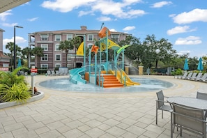 A water play area with slides and stairs, surrounded by a pool and lounge chairs. - BREAKVIEW LUXE AT VISTA CAY | NEWLY RENOVATED ULTRA LUXURIOUS CONDO | MINUTES FROM UNIVERSAL (Orlando)