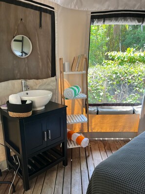 A bathroom with a sink, mirror, and towel rack.