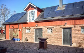 A red building with solar panels, stone walls, and a traditional design. - Stunning home in Sättra with WiFi (Sättra)