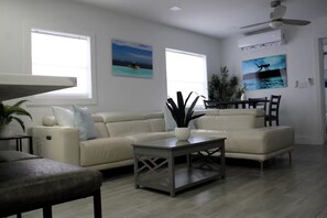 A living room with a beige sofa set, a coffee table, and a ceiling fan.