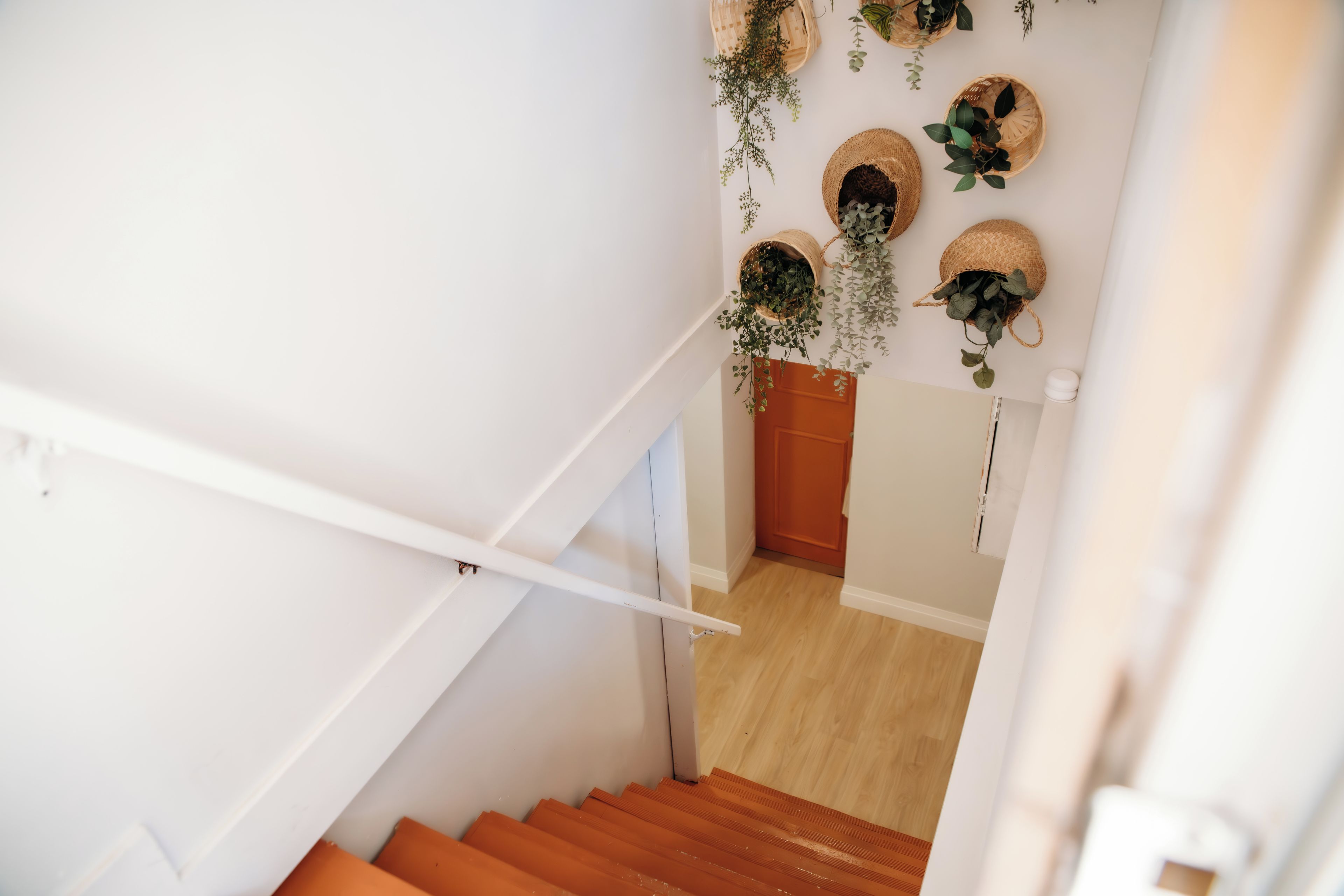 A staircase with a white handrail leading to a wooden door at the bottom.