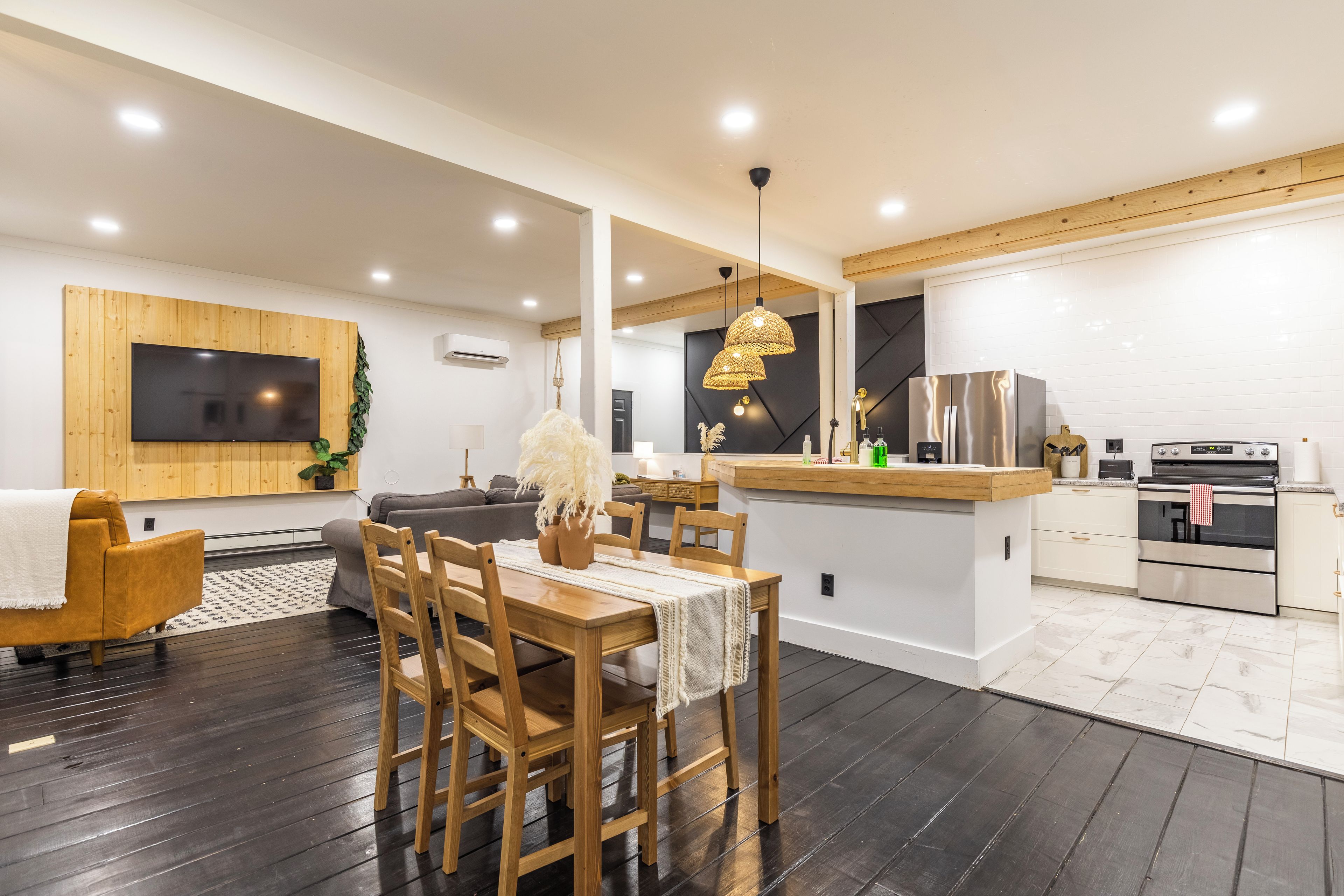 A modern kitchen with a wooden dining table, chairs, and a built-in island.