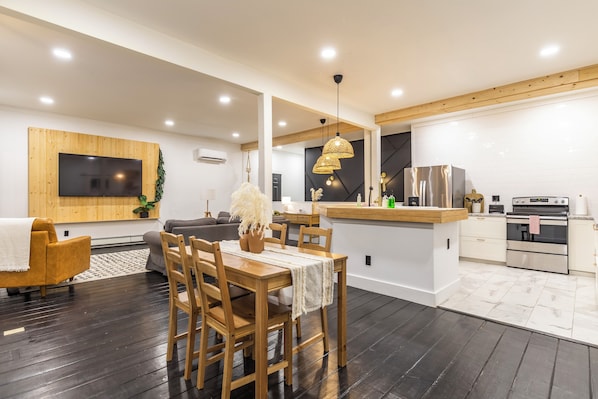 Una cocina moderna con una mesa de comedor de madera, sillas y una isla integrada.
