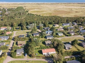 Ein Wohngebiet mit mehreren Häusern, Straßen und einem Strand im Hintergrund.