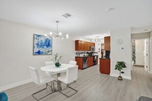 A modern kitchen with wooden cabinets, a built-in oven, and a stainless steel refrigerator. - Chic 1BR Getaway Pool & Tiki Bar Blocks from Beach (Fort Lauderdale)