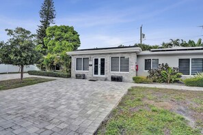 A two-story building with a flat roof, a front entrance, and a paved driveway. - Tropical Beachside Bliss – Pool, Tiki Hut & Bar (Fort Lauderdale)