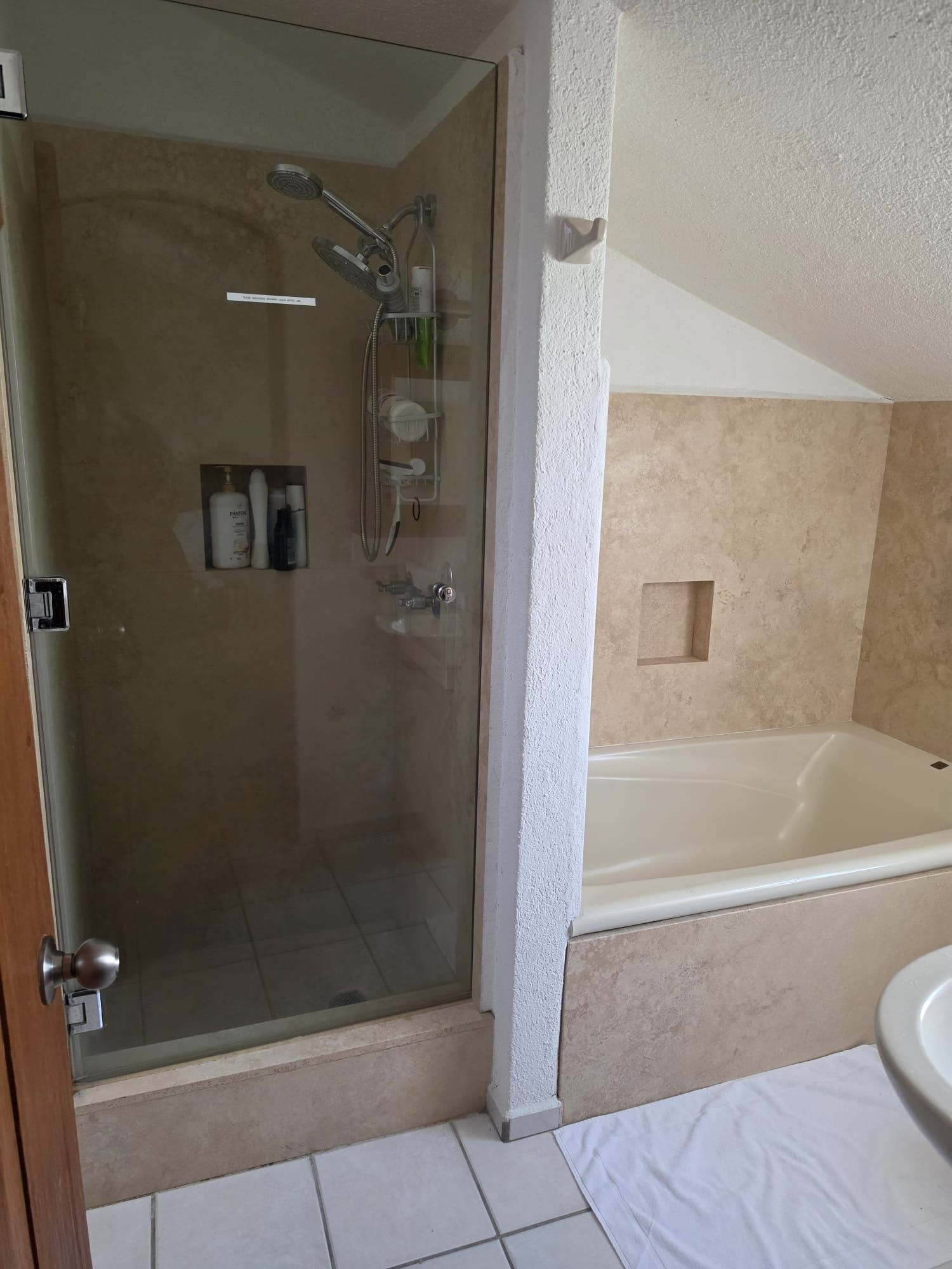 Un bagno con doccia vetro, vasca e WC.