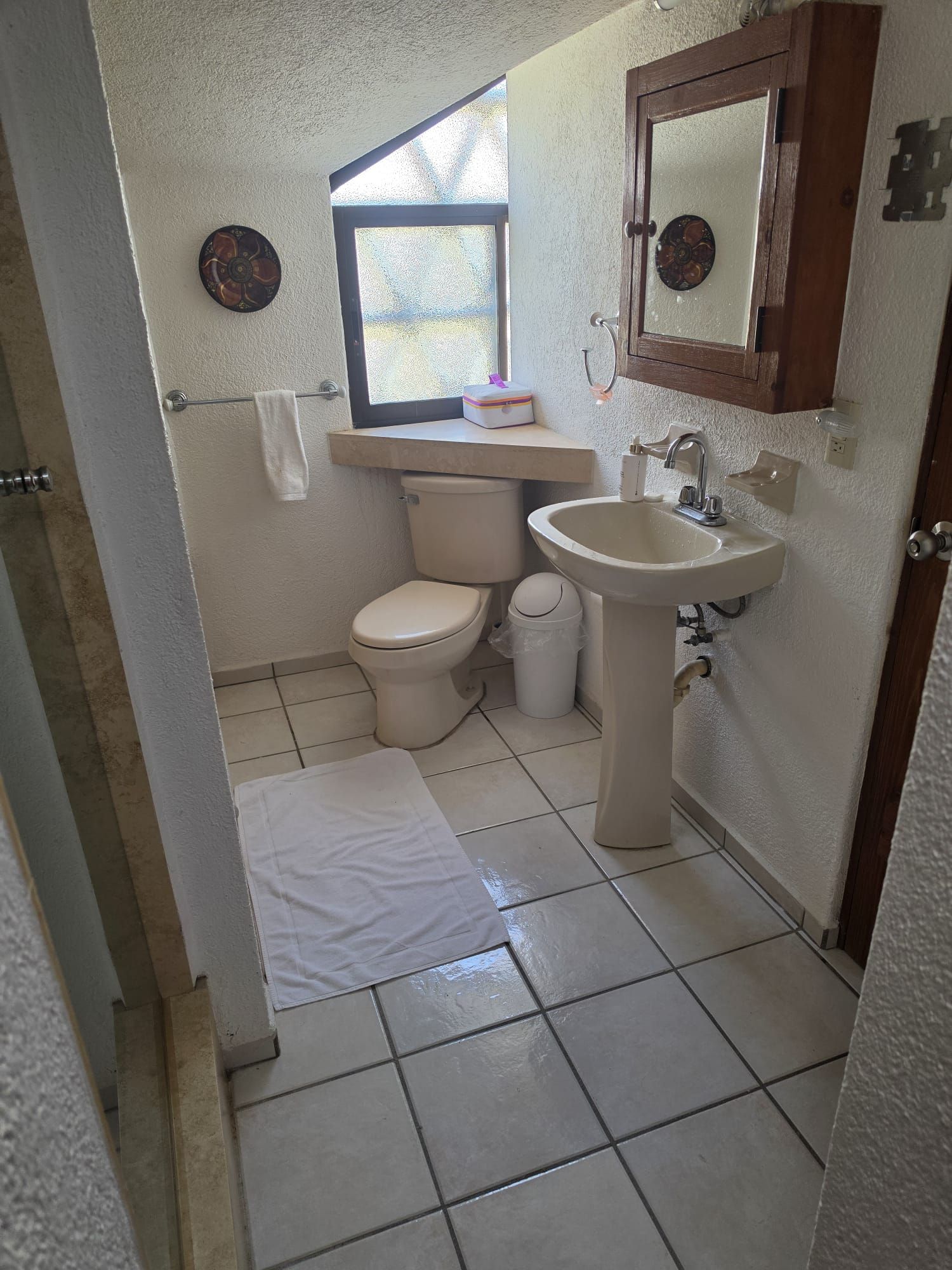 Un baño pequeño y limpio con inodoro, lavabo y ventana.