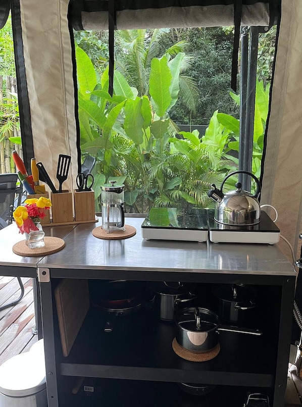 A kitchen counter with a coffee maker, a kettle, and utensils.