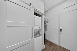 A hallway with a white wardrobe, a small shelf with items, and a door with a lock. - Down Under Loft · Bunk Studio for Riders (Bella Vista)